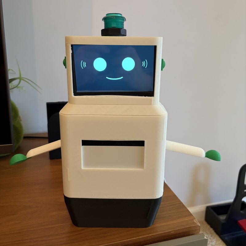 Link, a small cream robot with a smiling screen face and a green button on its head